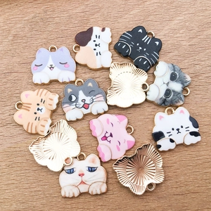 Flat lay of colorful enamel cat alloy charms for DIY jewelry on a wooden background