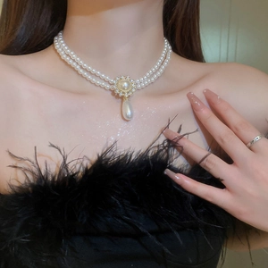 Détail du collier de perles double rang avec pendentif en cristal et perle en goutte