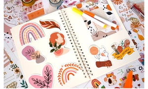 Flat lay of bohemian journal stickers with rainbow and floral patterns on an art journal