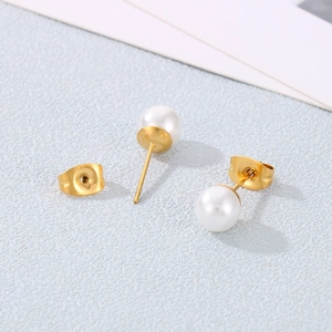 Gros plan détaillé de boucles d'oreilles perles dorées avec fermoirs sur fond bleu clair
