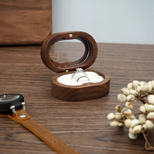 Macro view of walnut wood ring box with transparent top and white double slots