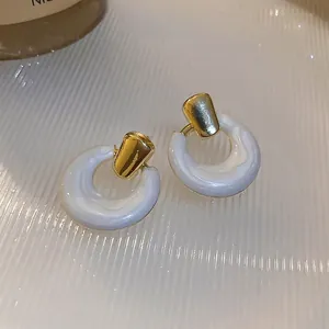 Elegant white marble-textured C-shape hoop earrings with gold trapezoid studs