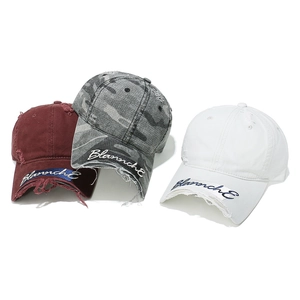 Detailed view of distressed baseball caps with Blanche embroidery and ripped details