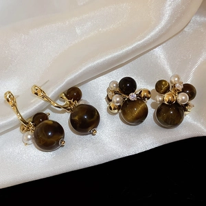 Macro shot of French vintage acrylic geometric earrings with zircon and pearl details