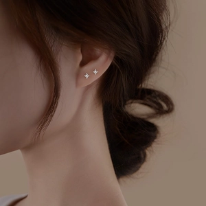 Elegant S925 sterling silver four-pointed star stud earrings worn on the earlobe