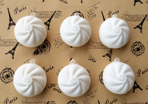 Close-up of 6cm soft PU steamed bun squishy charms with detailed spiral texture