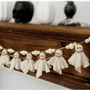 Halloween felt ghost and natural wooden bead garland hanging on a rustic wooden mantel
