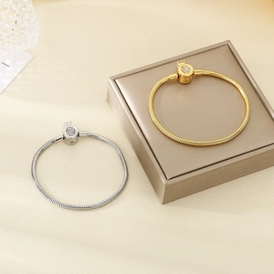 Detail of snake chain bracelets with sparkling crown clasps in gold and silver finishes