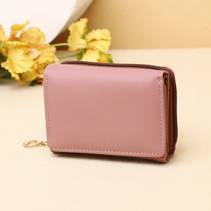 Detail of pink tri-fold wallet showing smooth PU leather and gold round zipper puller