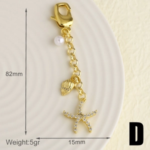 Vue détaillée du porte-clés étoile de mer dorée de 82mm avec de petites perles d'ornement