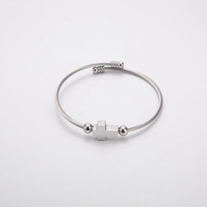 Detail of twisted cable stainless steel bracelet featuring cross and bead accents