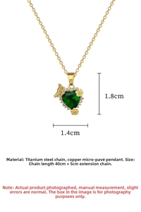 Detail of titanium steel heart pendant with green gemstone and floral micro-insets