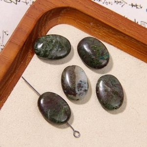 Detailed view of five oval natural stone beads with green and reddish-brown textures