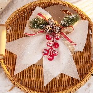 Christmas bow decoration with glitter, pine cones and red berries for tree hanging display