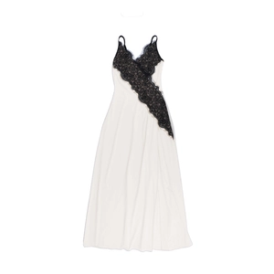 Detail of white maxi slip dress showing black lace floral trim and silky fabric texture