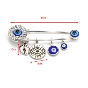 Detailed view of silver evil eye safety pin brooch with hanging charms and dimensions