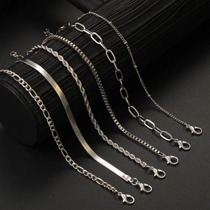 Detailed close-up of six silver-colored metal chain bracelets featuring various link styles