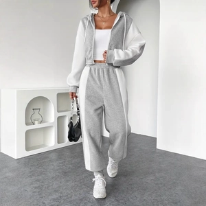 Detail of grey and white contrast tracksuit showing zipped hoodie and joggers fit