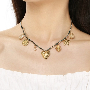 Close-up of bohemian woven rope necklace with a gold hammered heart pendant and star charms