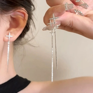 Silver bow earrings with star pendant and long sparkling diamond tassels on model