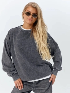 Detail of loose-fit washed grey sweatshirt featuring drop shoulder design and cotton texture