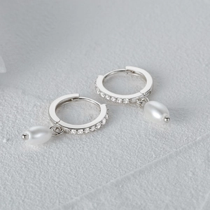Detailed view of elegant silver pearl drop earrings with sparkling cubic zirconia inlay