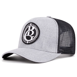 Détail du tissu en sergé gris et du filet noir respirant sur la casquette trucker rétro