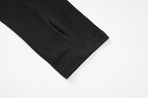 Détail des manches du haut en maille noir avec passe-pouces et coutures de précision