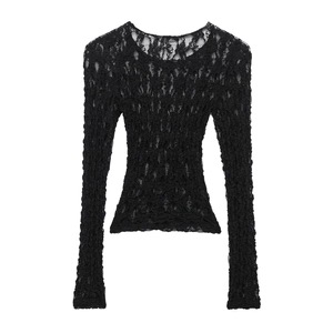Detailed view of black lace knit top featuring sheer hollow-out floral patterns and crew neck