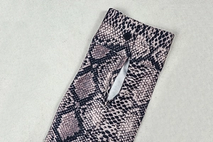 Detail of snake print sleeve cuff featuring a single black button on a flare pants set