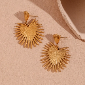 Close-up of golden sunburst earrings with a textured surface and bohemian retro style