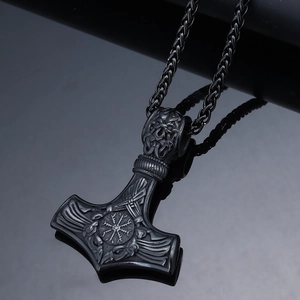 Macro detail of gunmetal Viking Mjölnir pendant with intricate knotwork engravings