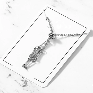 Macro detail of silver geometric cage pendant on adjustable mesh stone necklace