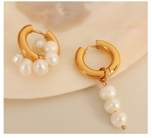 Vue détaillée de boucles d'oreilles créoles dorées asymétriques avec perles sur nacre