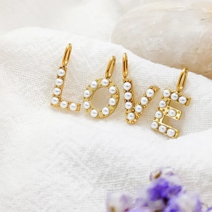 Detailed macro view of 14K gold plated pearl LOVE letter pendants for DIY jewelry