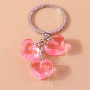 Detail of three pink translucent resin heart charms attached to a silver keychain ring