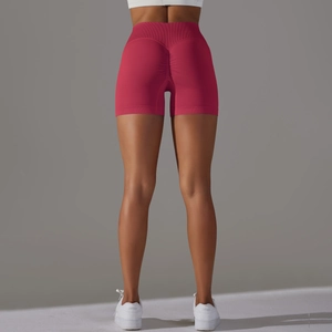 Dettaglio macro degli shorts da yoga rossi a vita alta con effetto scrunch