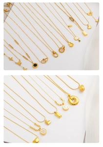Detailed macro view of various gold titanium necklaces with heart and butterfly pendants