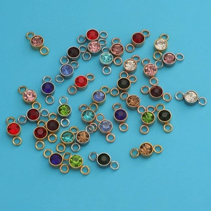 Detailed view of stainless steel birthstone charms with diverse colors and metal finishes