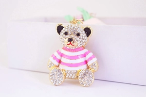 Detailed close-up of a sparkling teddy bear keychain with pink and white stripes