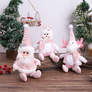 Three-piece pink and white plush Christmas dolls with sequins on wooden table decor