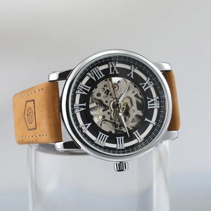 Macro shot of mechanical watch dial with Roman numerals and brown leather strap details