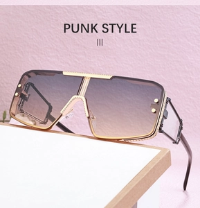 Close-up of gold metal frame punk sunglasses with rivets and gradient brown lenses