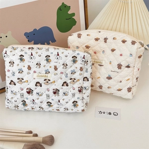 Close-up of quilted cosmetic bags with cute bread dog patterns and zipper detail