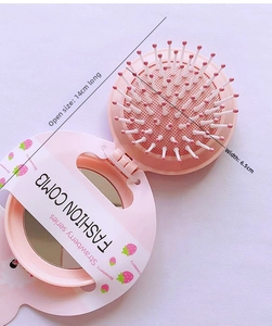 Detail showing the portable strawberry folding hairbrush mirror set dimensions and pink design