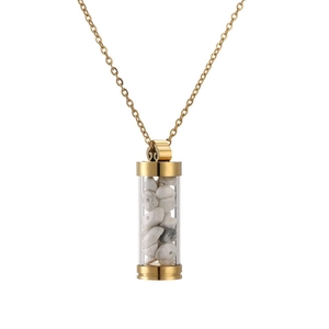 Detailed macro of a gold cylinder pendant necklace filled with white natural stones