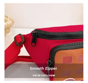 Detail shot of a kids nylon crossbody bag featuring a smooth black resin zipper and red fabric
