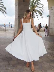 Gros plan sur la robe blanche rétro à col carré avec un tissu fluide élégant au soleil