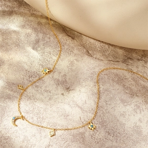 Detail of gold moon and star charms with blue opal stones on s925 silver necklace