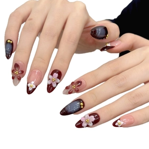 Almond press-on nails with 3D floral carvings and dark cat-eye marble design
